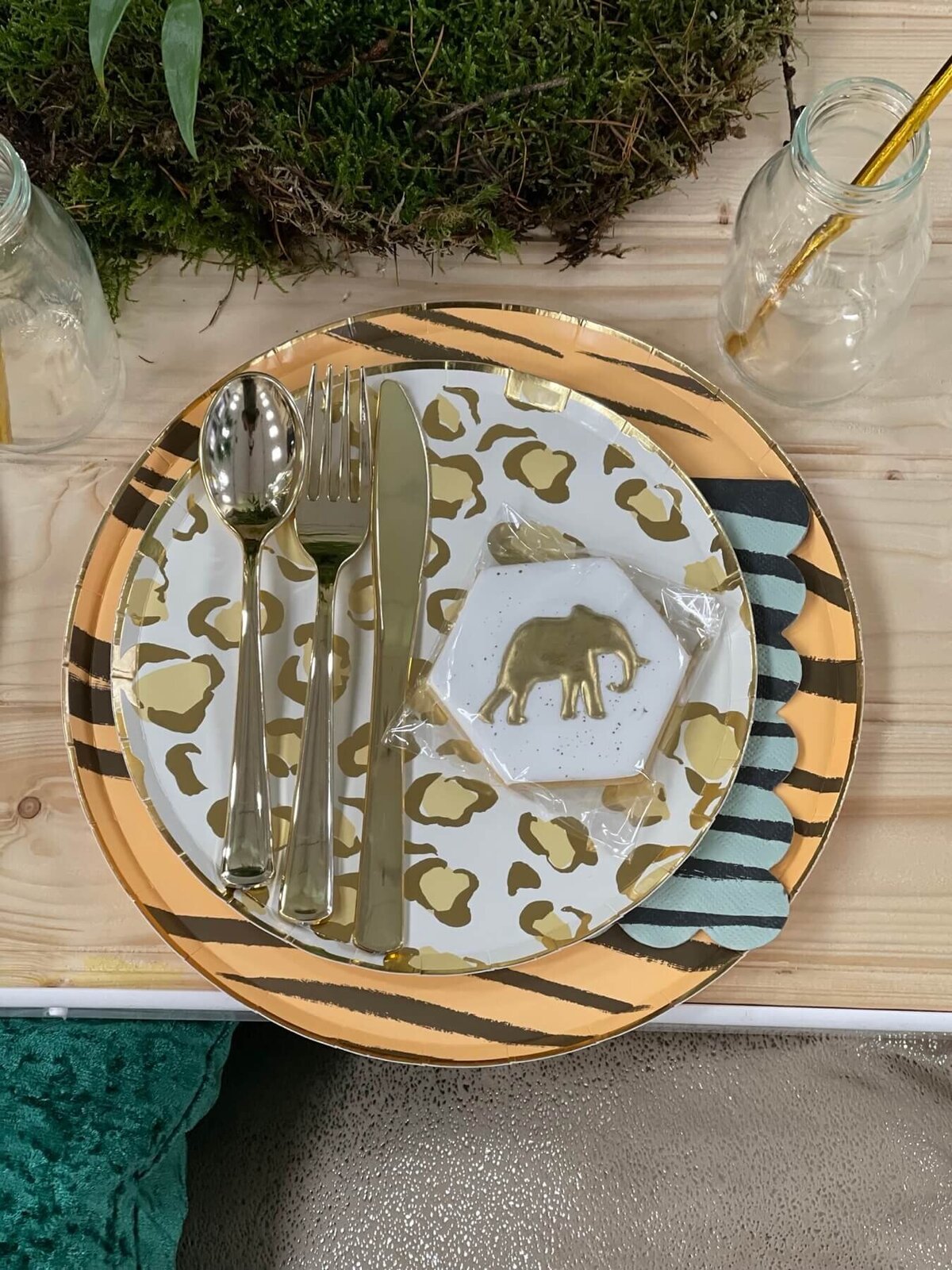 Jungle plate setting with white iced biscuit favour with a gold elephant