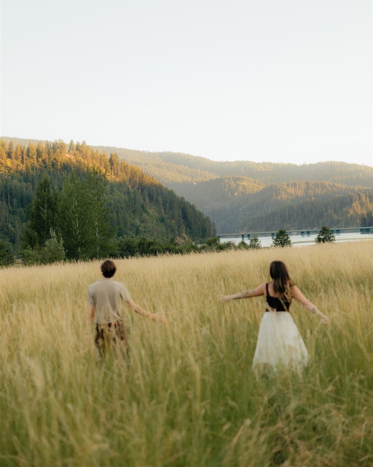 couple running through tall grass