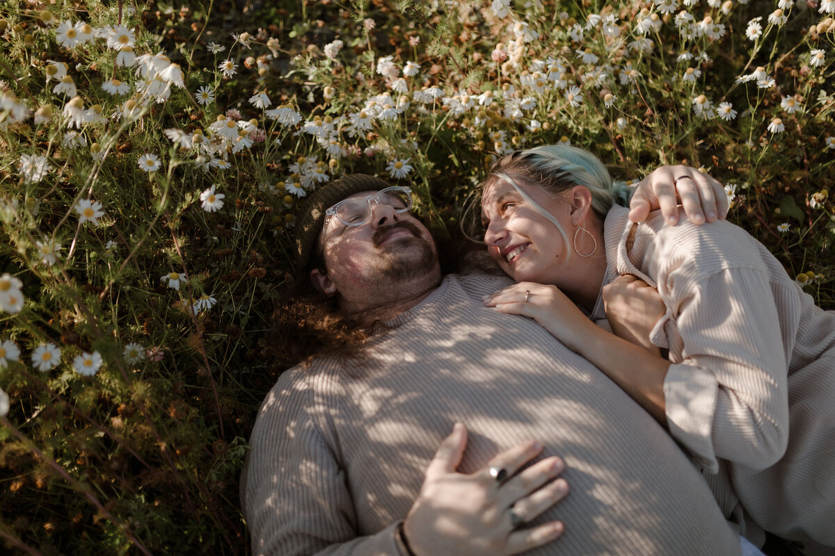 couple laying in daisies
