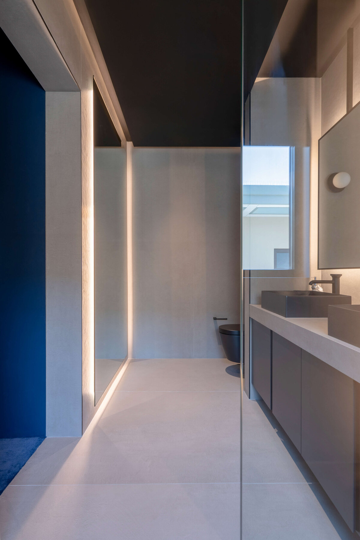 Entrance to a sleek grey bathroom en suite.