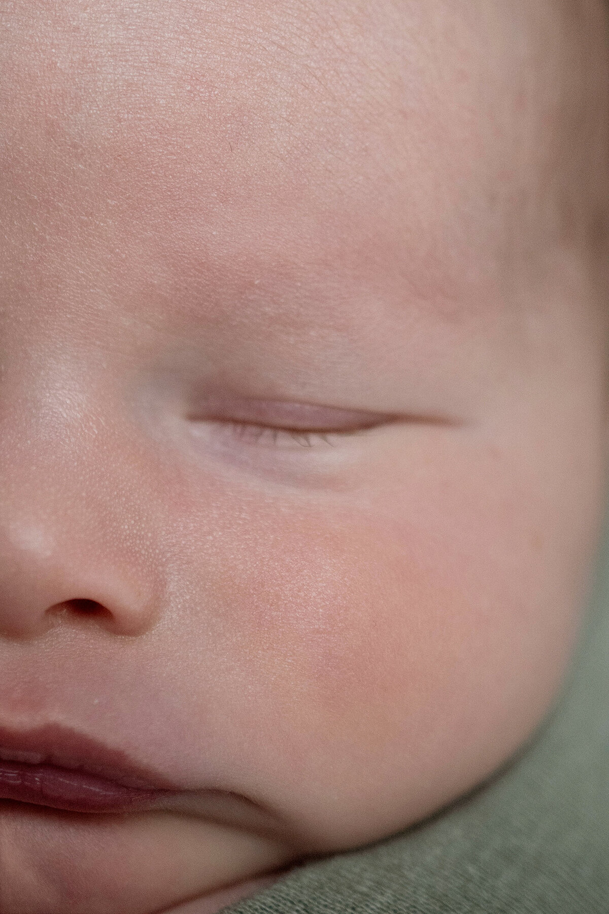 The closed eye of a sleeping newborn baby