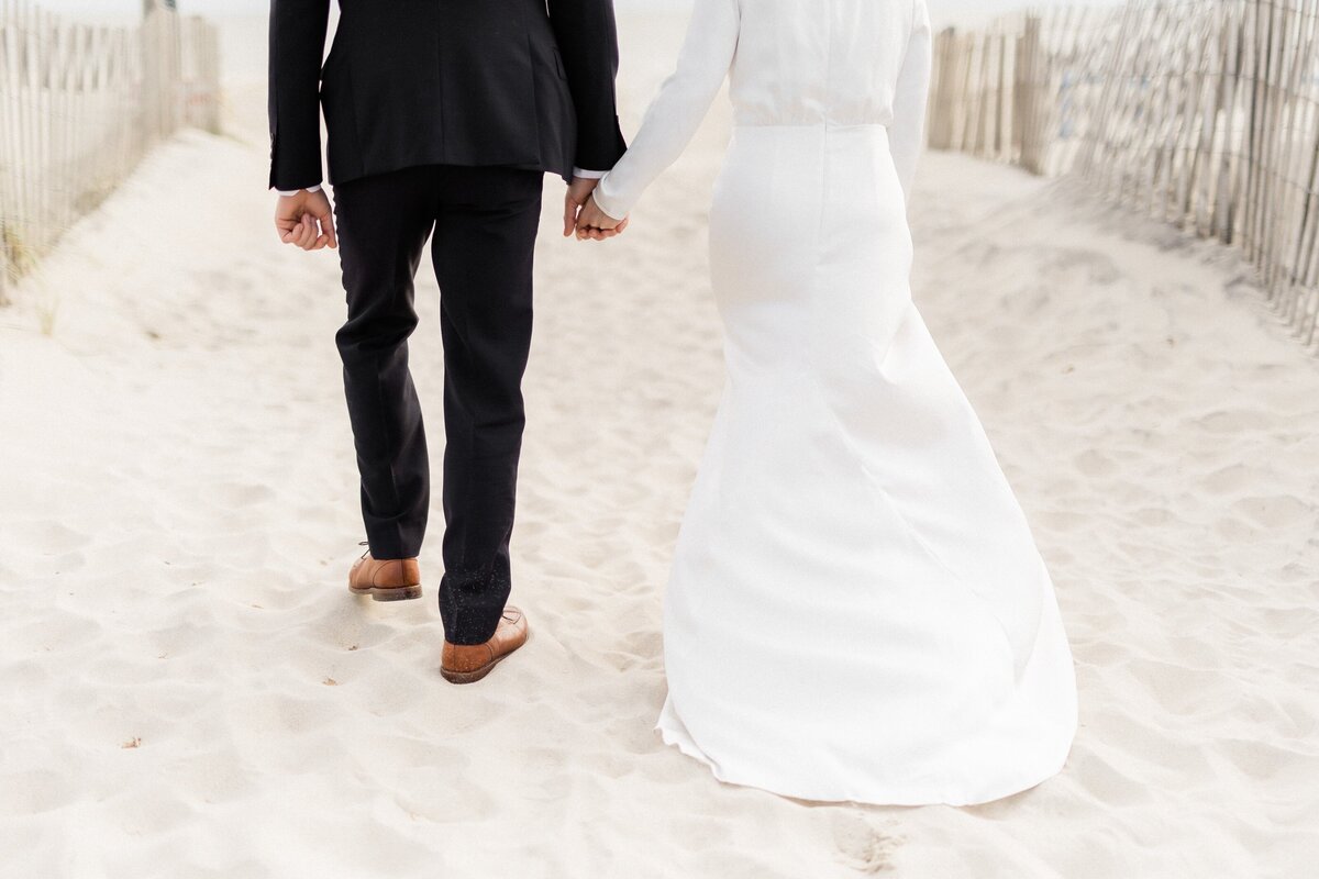 Bride and groom walking towards the beach in Cape May