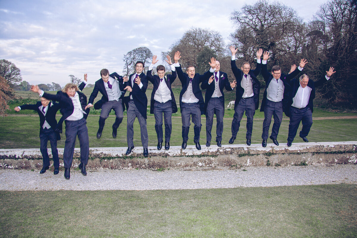 pro-story-photography_male-bridal-party-jumping-off-wall_fun-photo_kitley-house_yealmpton_devon