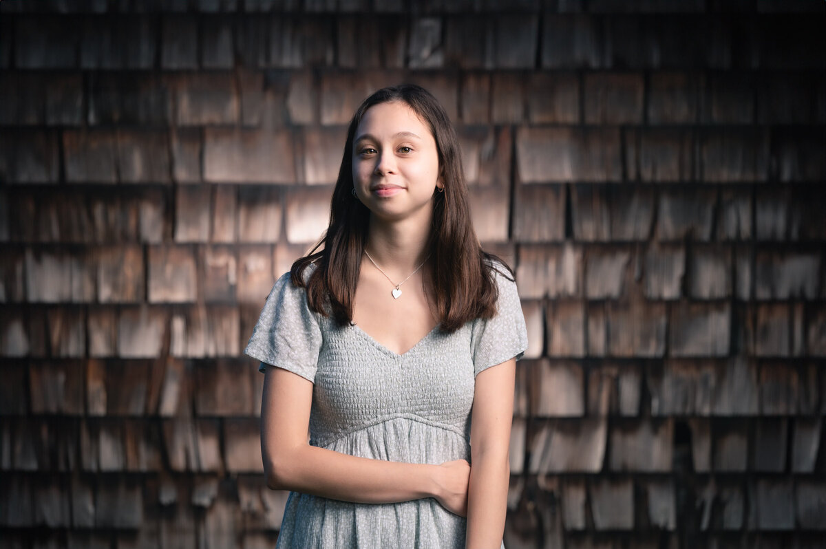 Senior portrait of Boston teen girl in front of barnwood shingles