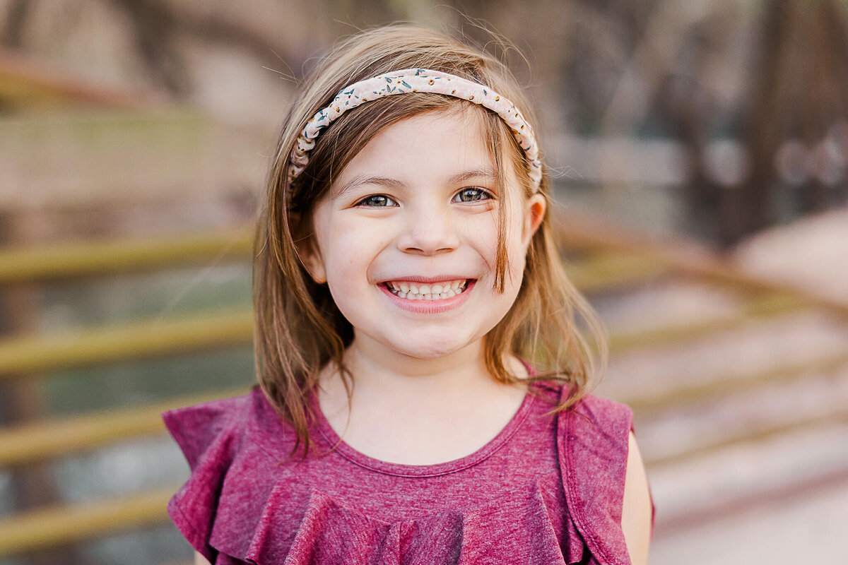 Young girl in purple dress smiling for camera