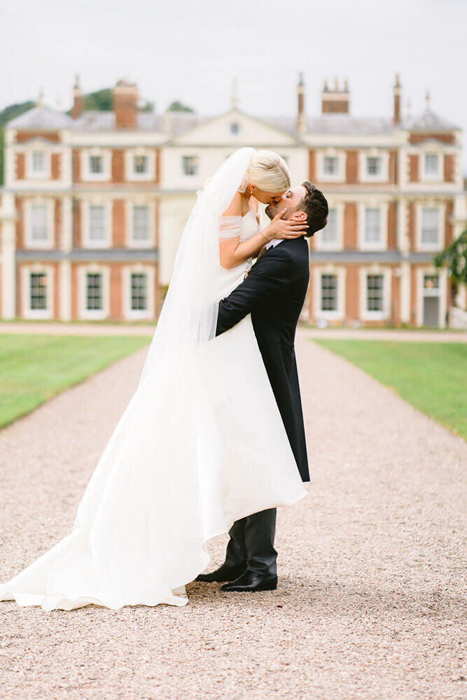 groom picking up bride and kissing her at hawkstone hall