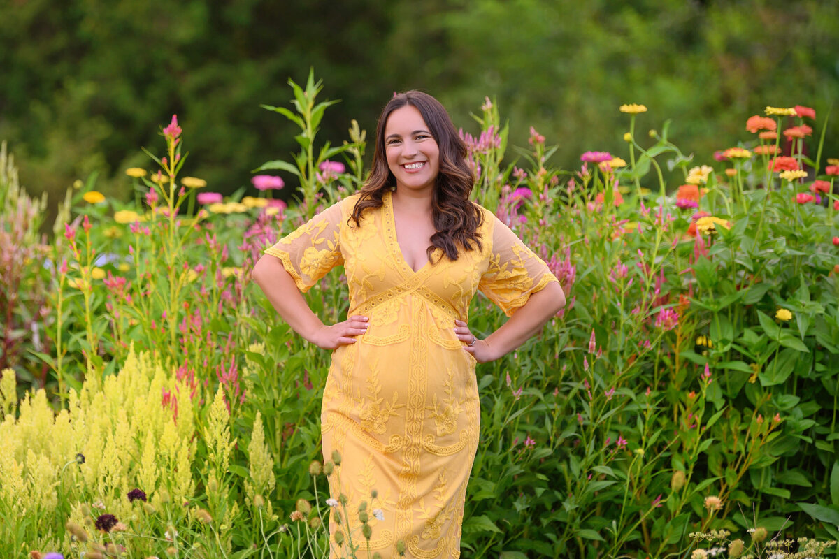 maternity photos in a flower field.  woman wearing a yellow dress.