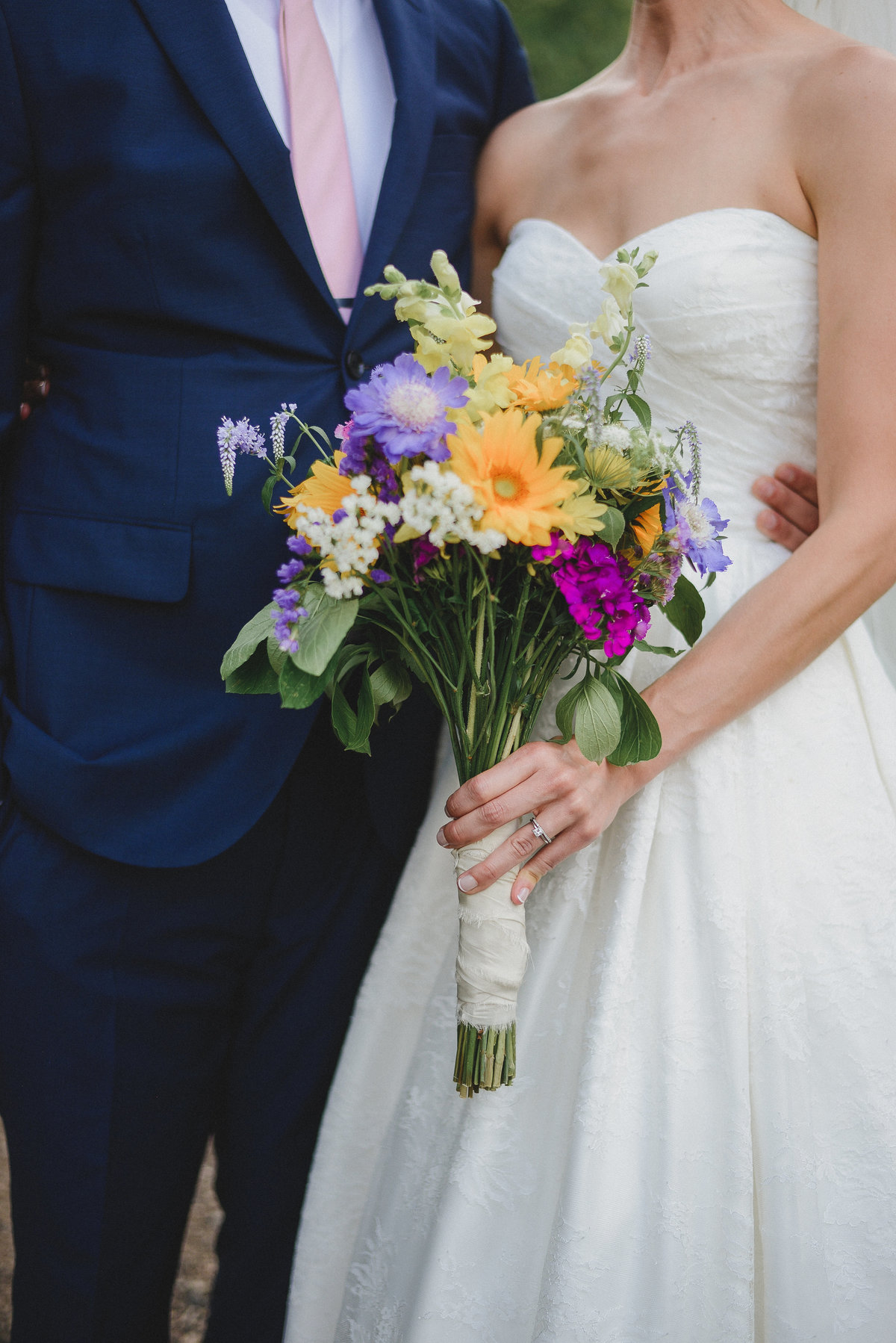 brides spring bouquet with groom in blue suit