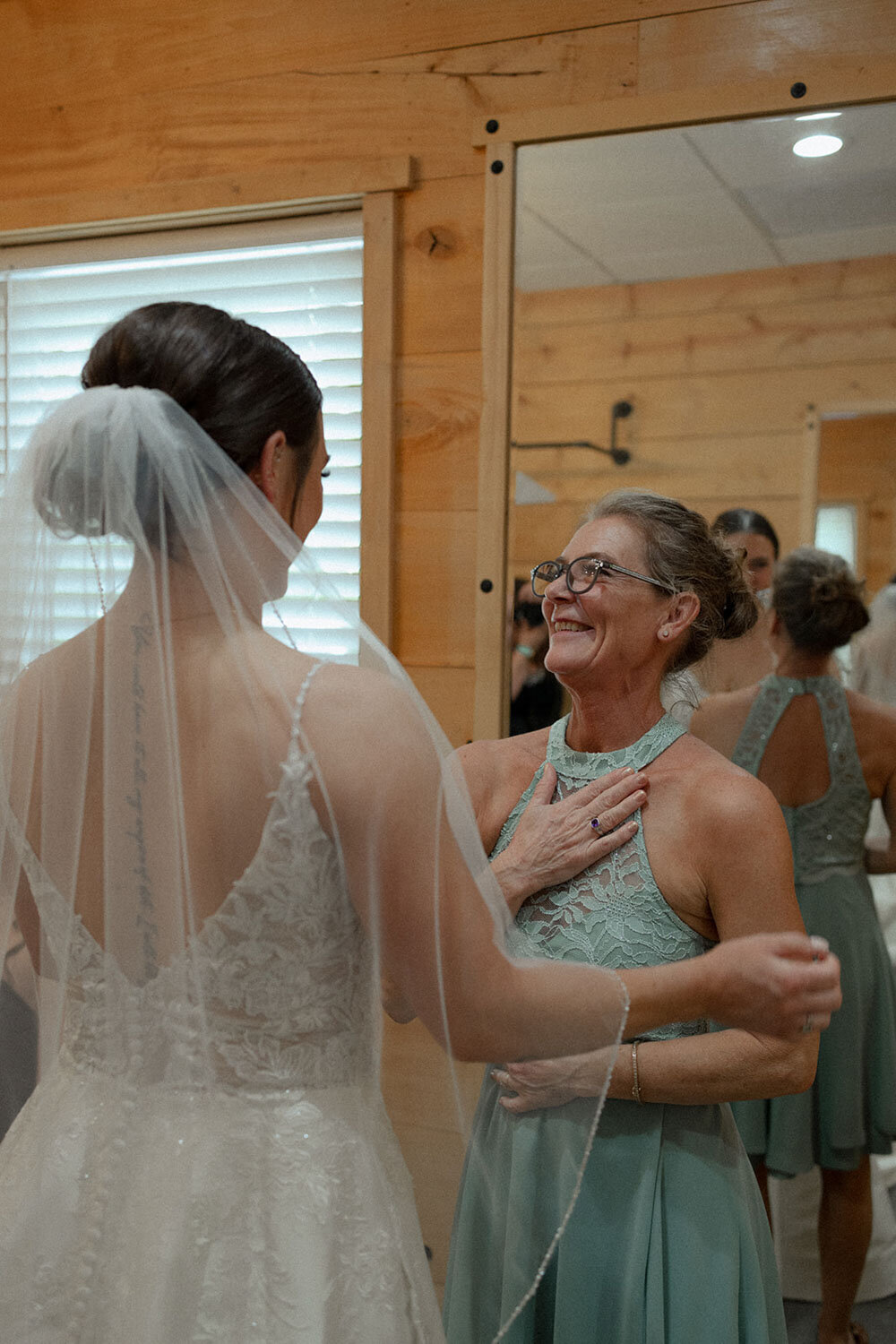 Bride in veil with her mother in an emotional embrace