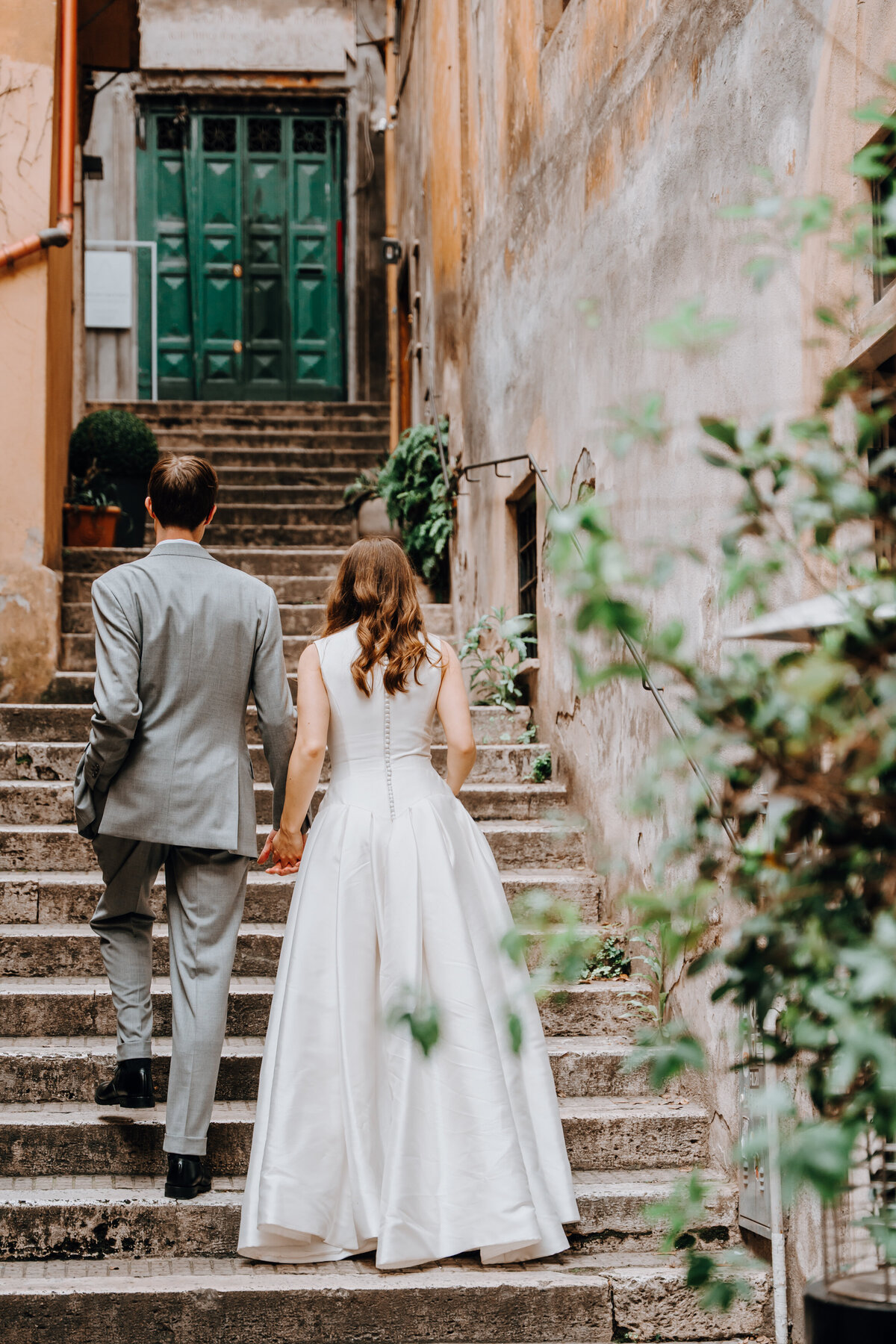 Couple walking together through cobblestone alley in Rome.