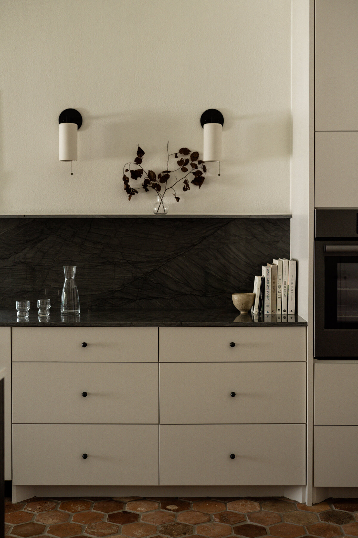 Timeless vintage cottage kitchen with antique terracotta tiles, stained oak island, triple seven home lighting, and quartzite countertops by House Franc in Austin