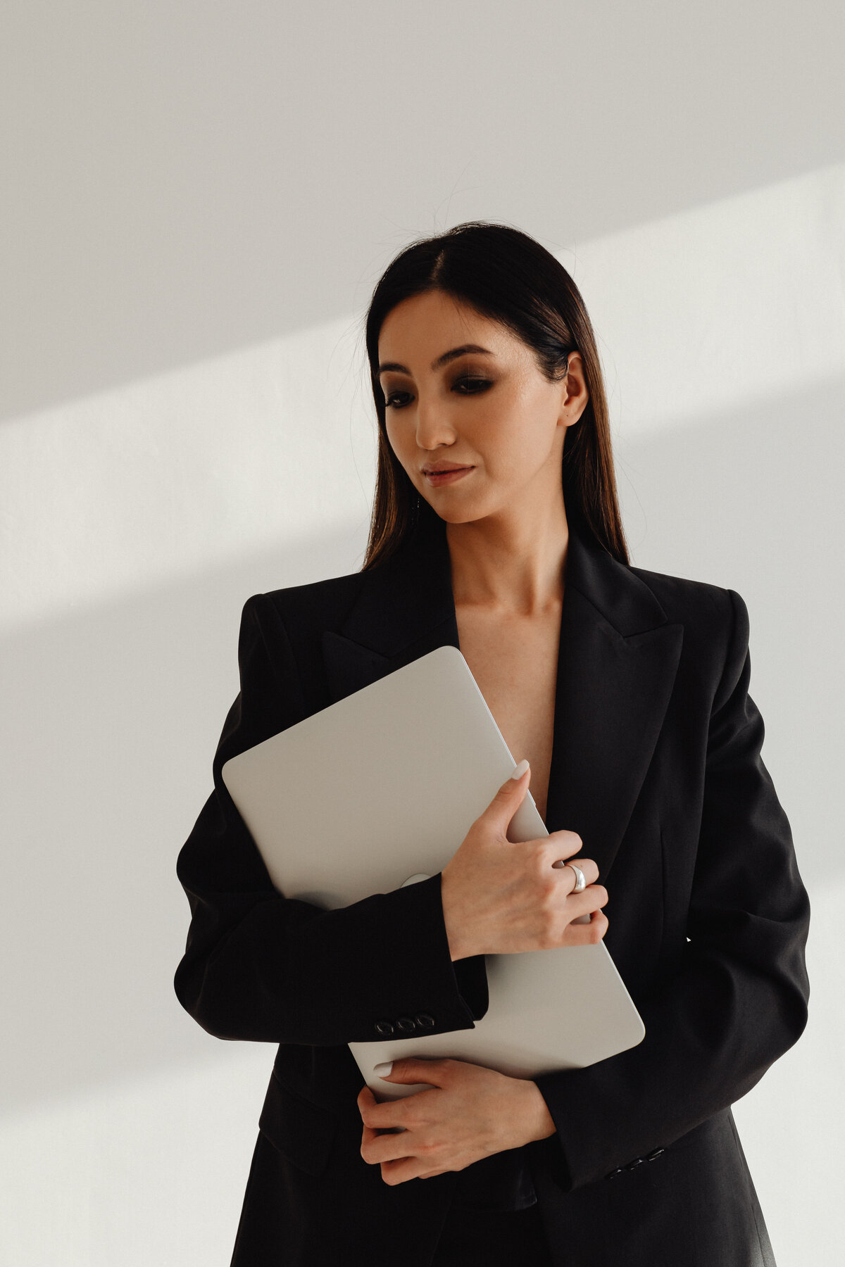 Female Entrepreneur in blazer holding a laptop