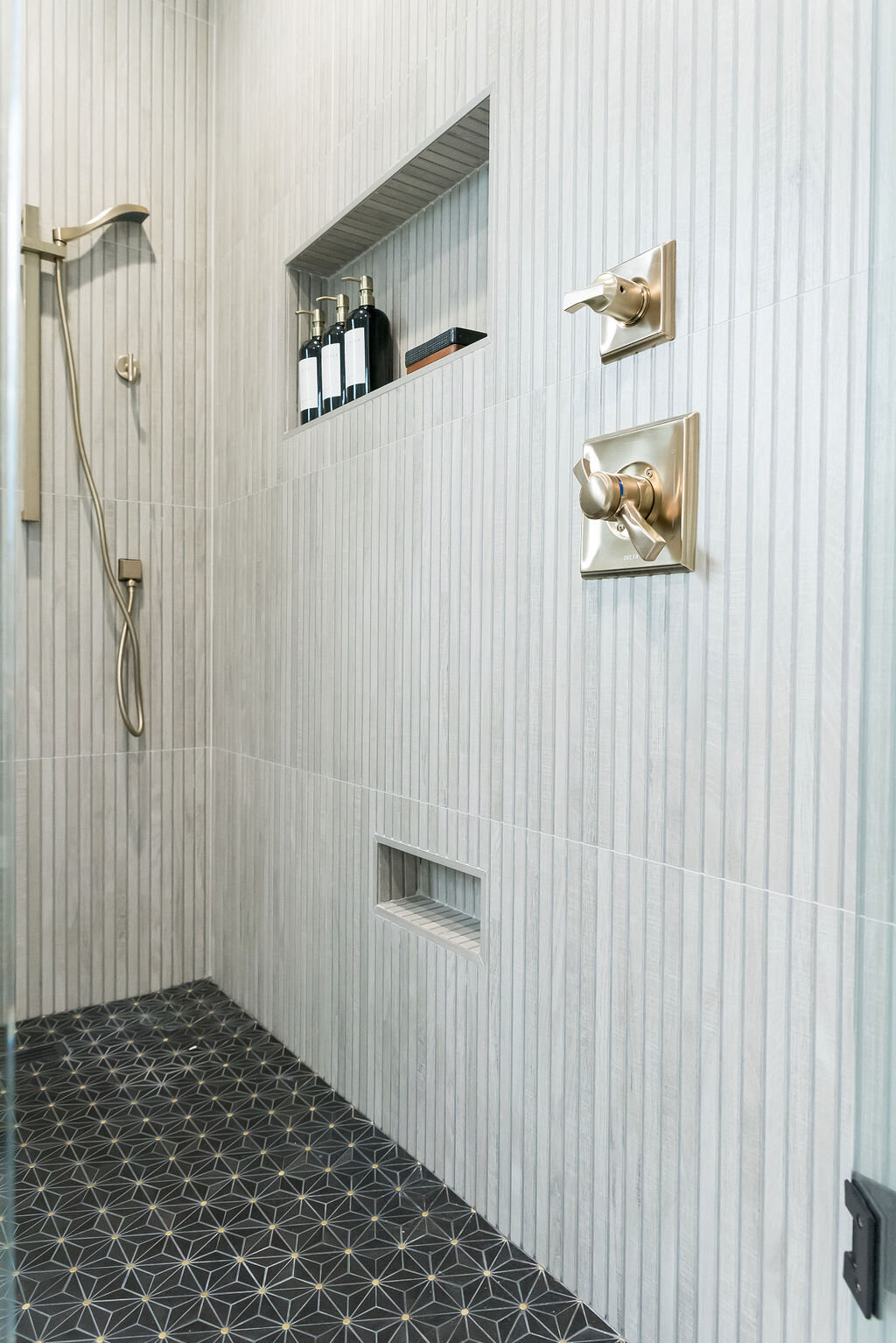 dewine design interiors hotel lux large walk-in shower with dark flooring