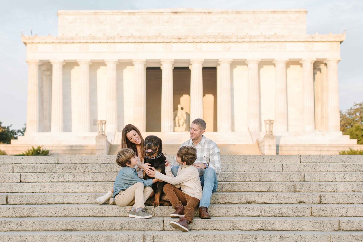 family with dog sitting on lincoln memorial steps