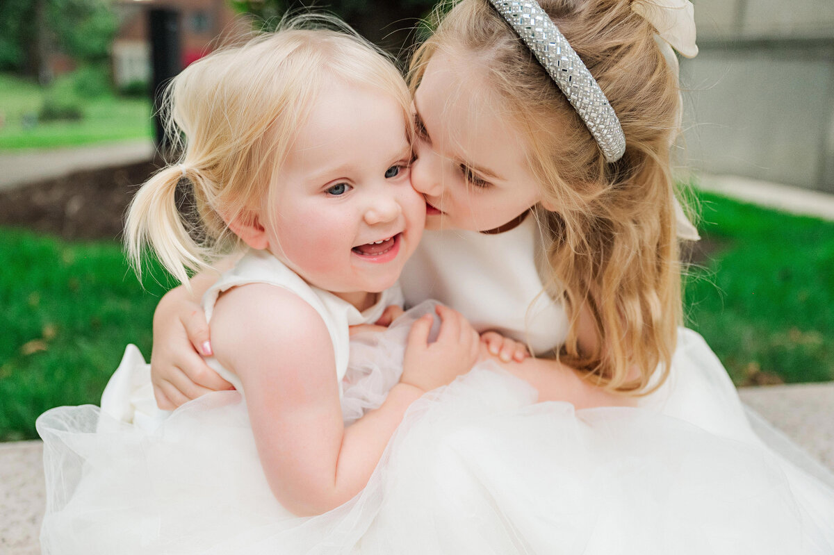 flower girls snuggling on wedding day