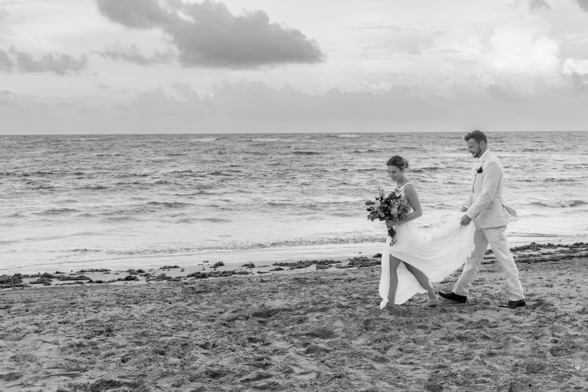 Bride and groom walk on the beach after their ceremony