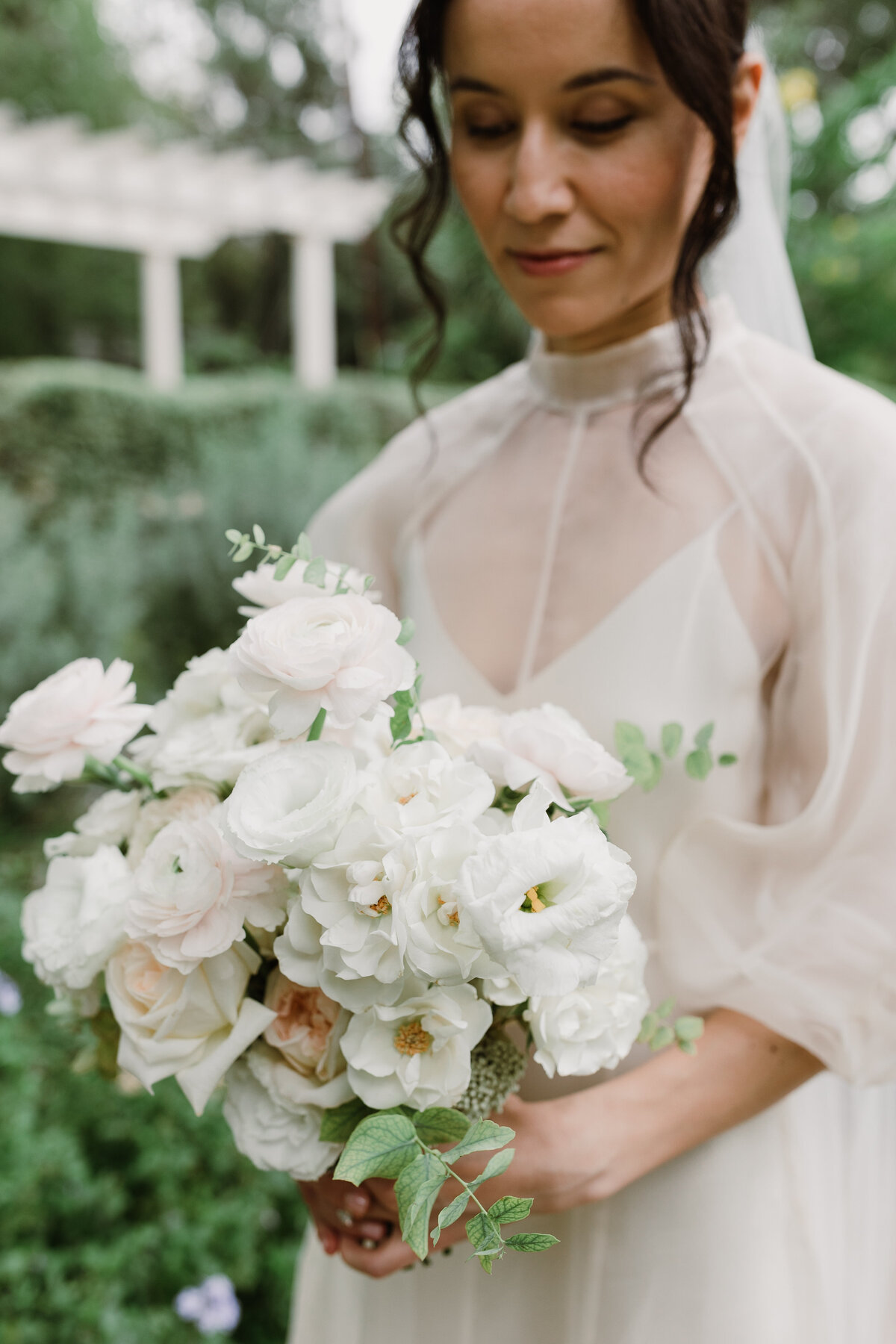 Bride holding bouquet of white florals for wedding at Laguna Gloria, Austin