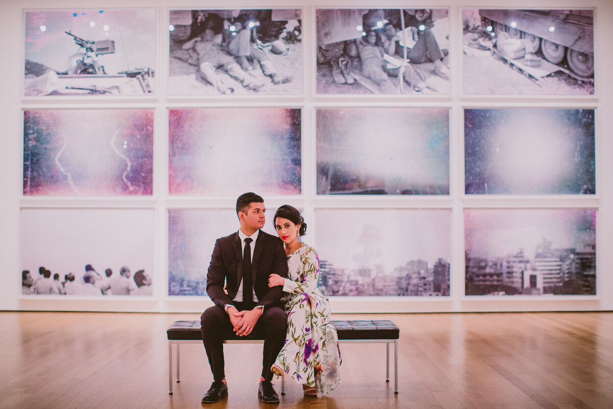 A couple sitting on a bench in an art exhibit at the moma museum of modern art in nyc
