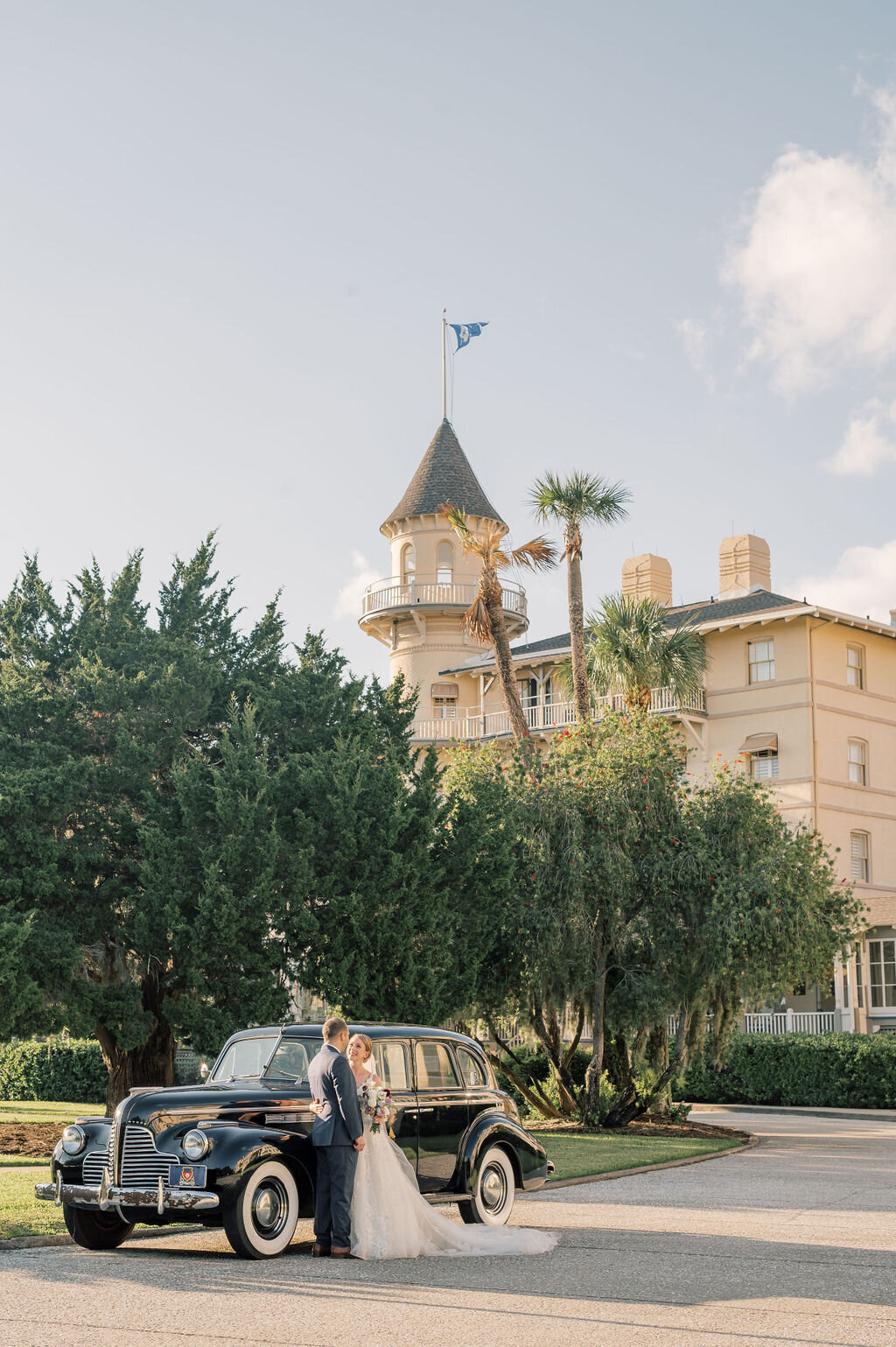 photo of bride and groom looking at each other in front of their vintage getaway car, taken by Jekyll Wedding Photographer, Rhonda Rowell
