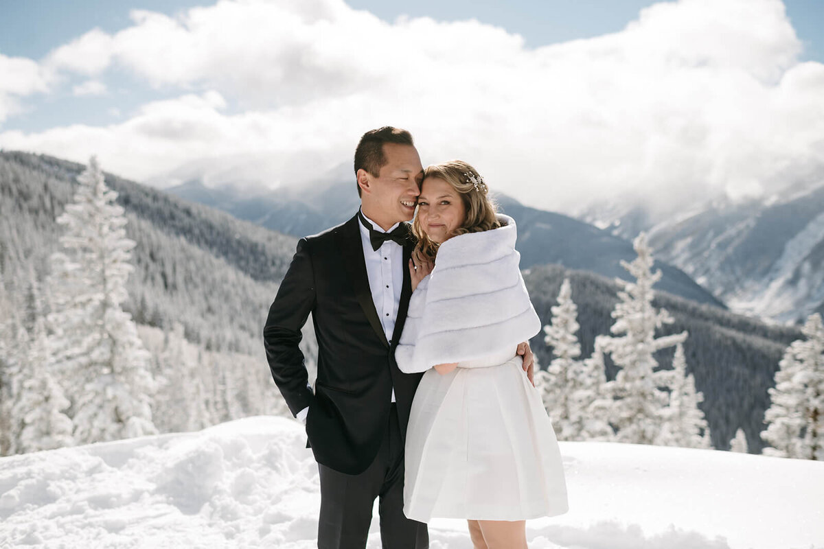 bride and groom embracing on mountain top