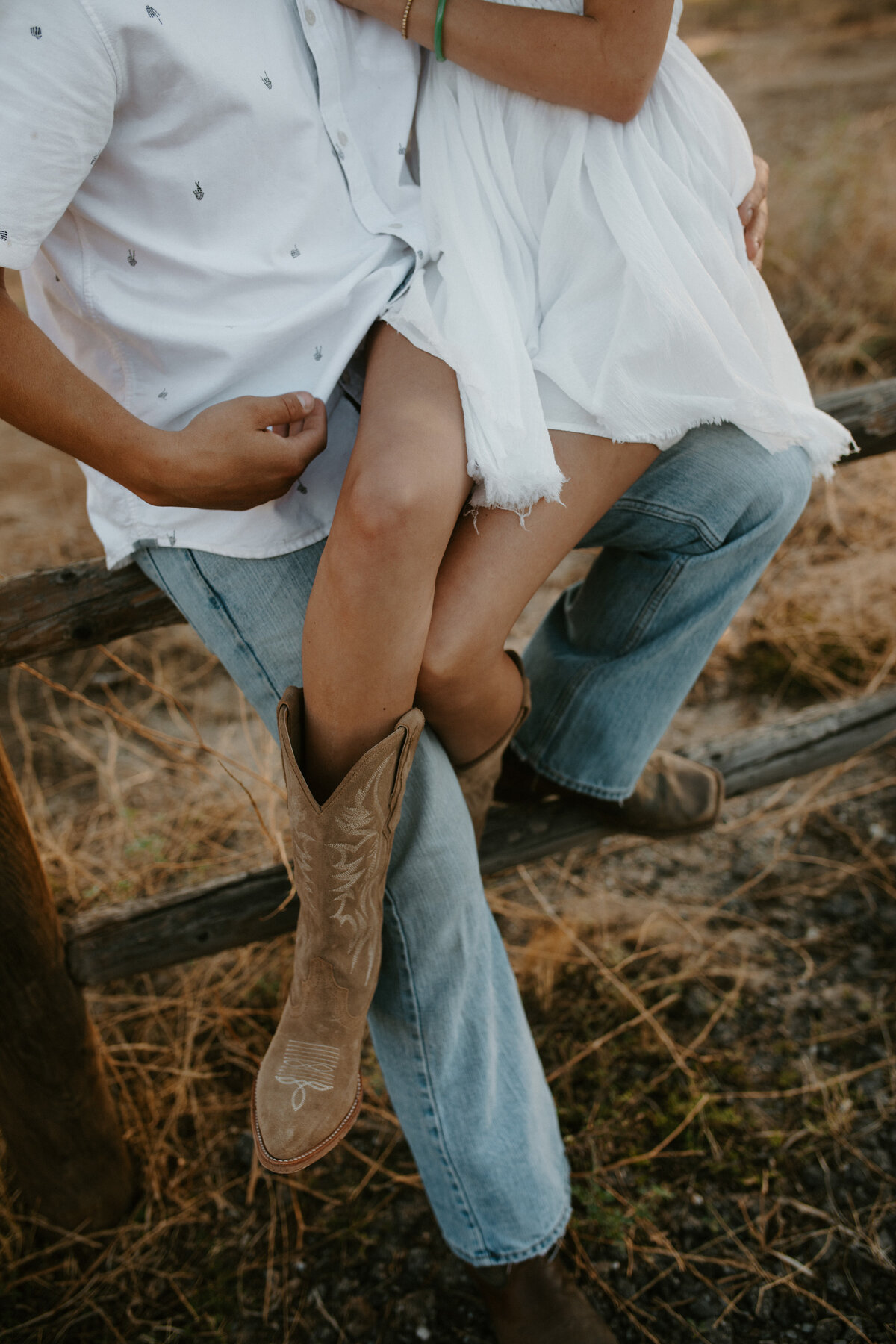 white dress and cowgirl boots sitting on guys lap