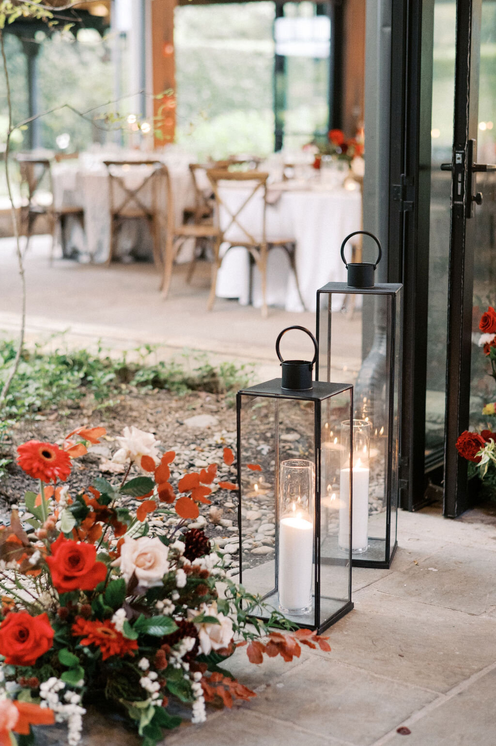 Red floral arrangements and lanterns at a luxury wedding reception in Highlands, NC. 