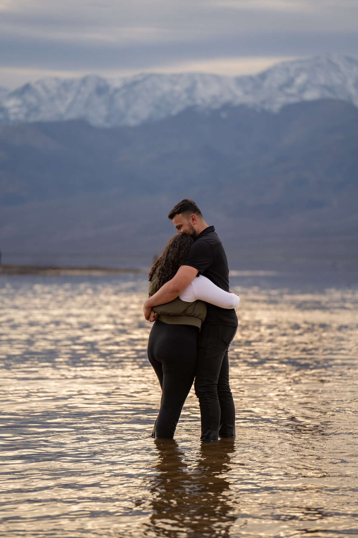 A couple hugging while standing in shallow water