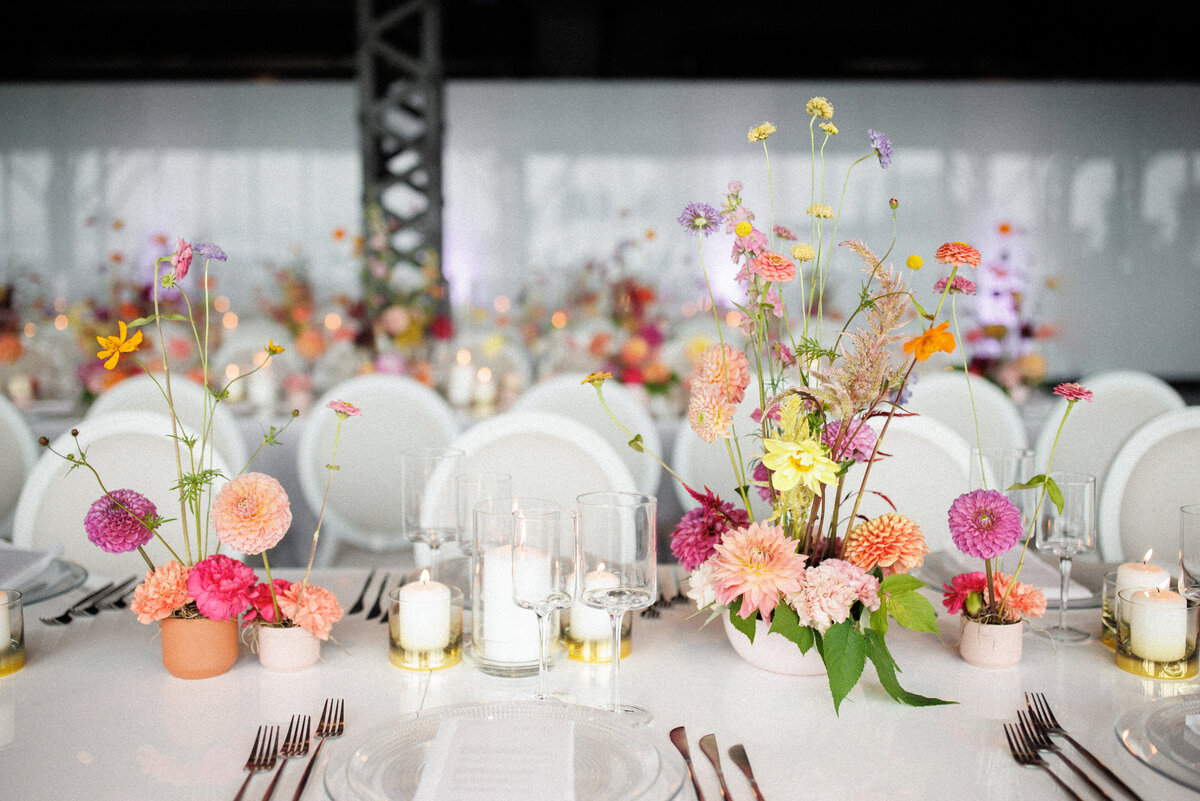 An arrangement of colourful, whimsical floral centrepieces at a Science Centre wedding reception.