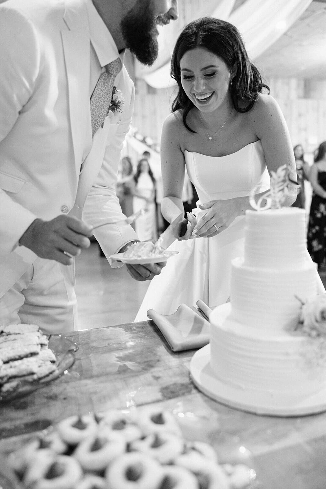 Bride and groom cutting cake at Finger Lakes wedding, NY at Wolf Oak Acres