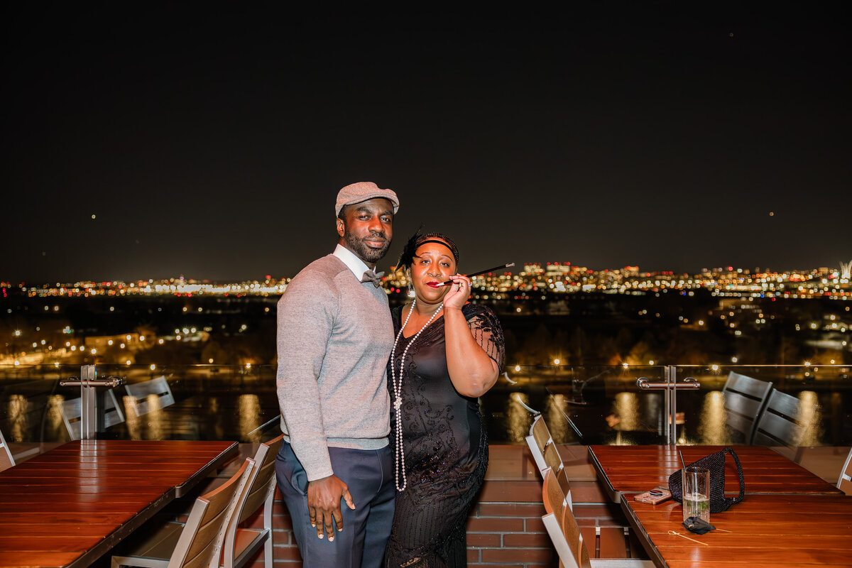 A posed picture of a couple during a corporate holiday party overlooking DC. Captured by event photographer Branden Gonzalez, of Brandgo Photos