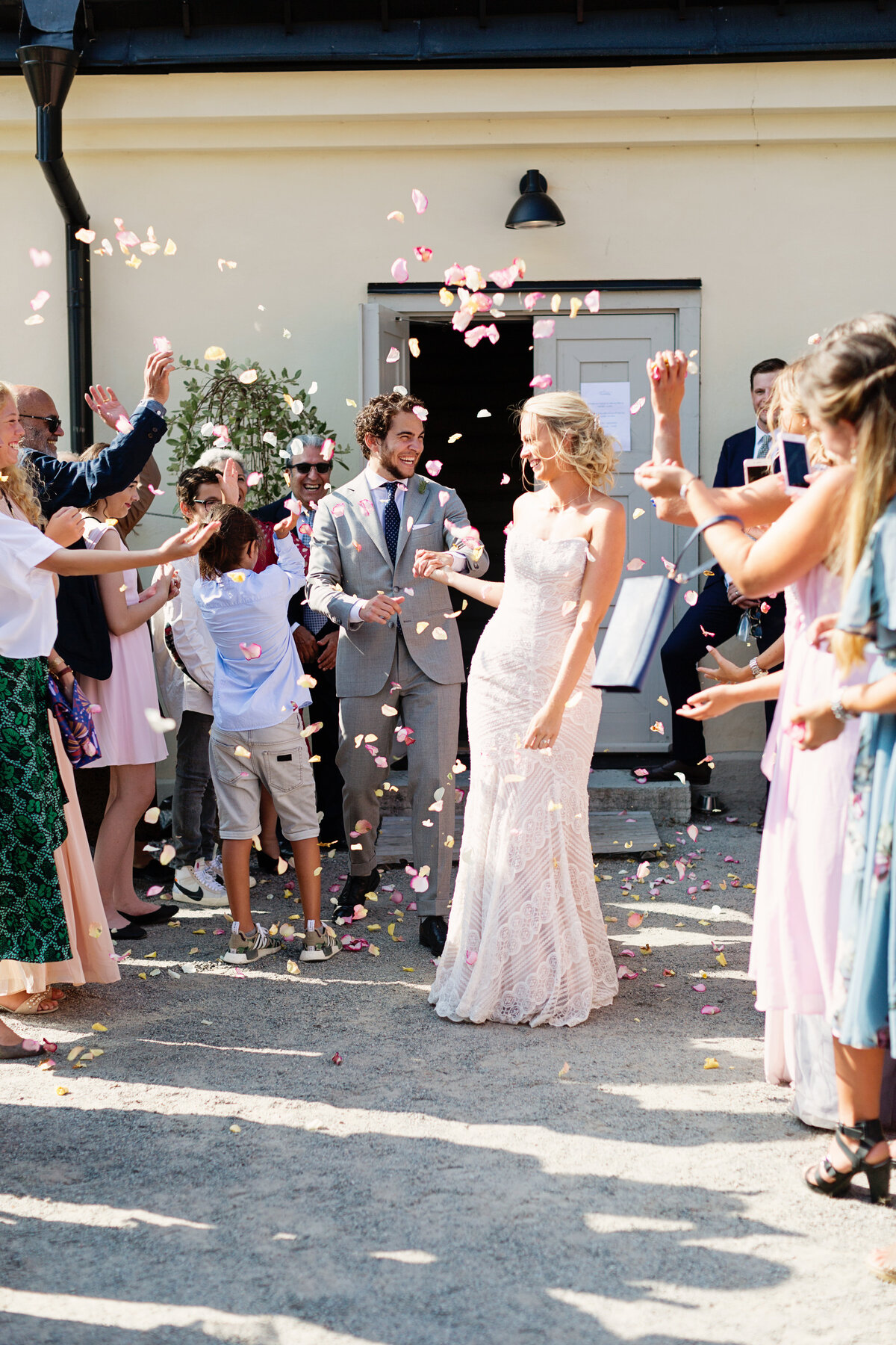 Bröllopsgäster kastar blomblad på brudpar utanför Fredriksborgs Hotell på Värmdö