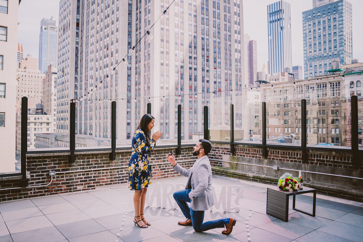 A couple proposing on an nyc rooftop jay suites with the marry me sign