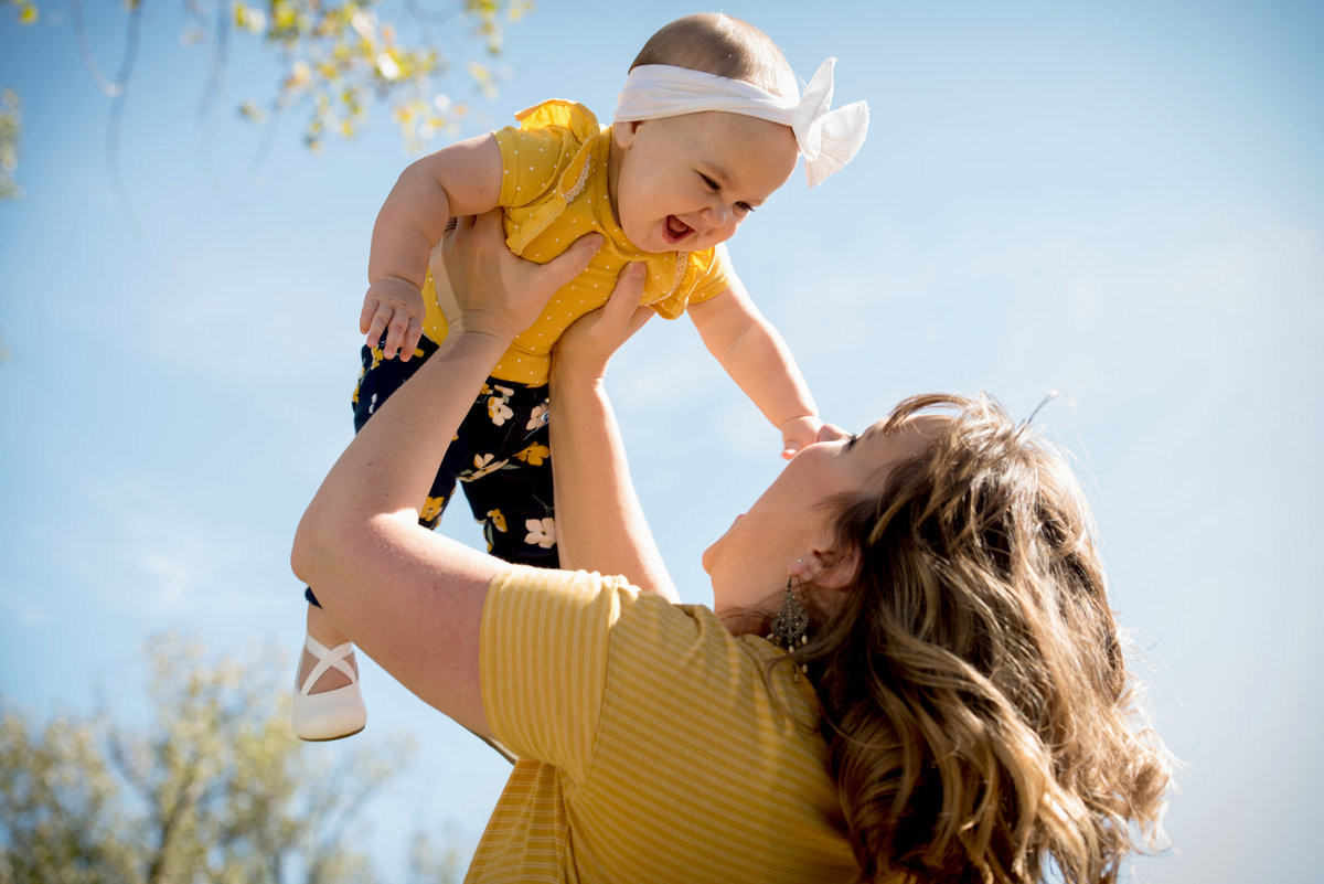 family-portrait-lifting-baby-with-head-bow-in-the-air-in-sycamore-illinois