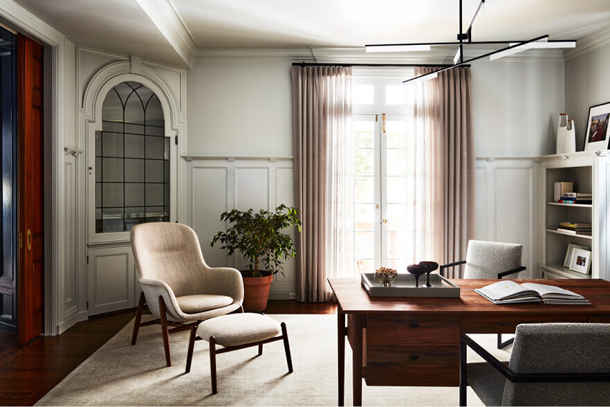 A light grey home office in a historic home blends mid-century modern furniture with classic interior design for a refined, timeless workspace.