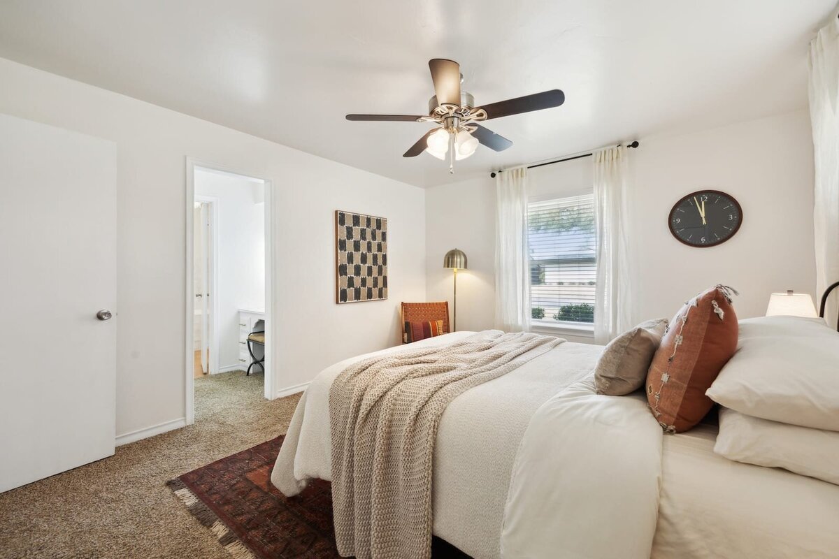 Primary bedroom at 3120 Chapel Downs Dr Dallas TX featuring soft natural light, neutral tones, and cozy layered bedding — Haven Realty Group.