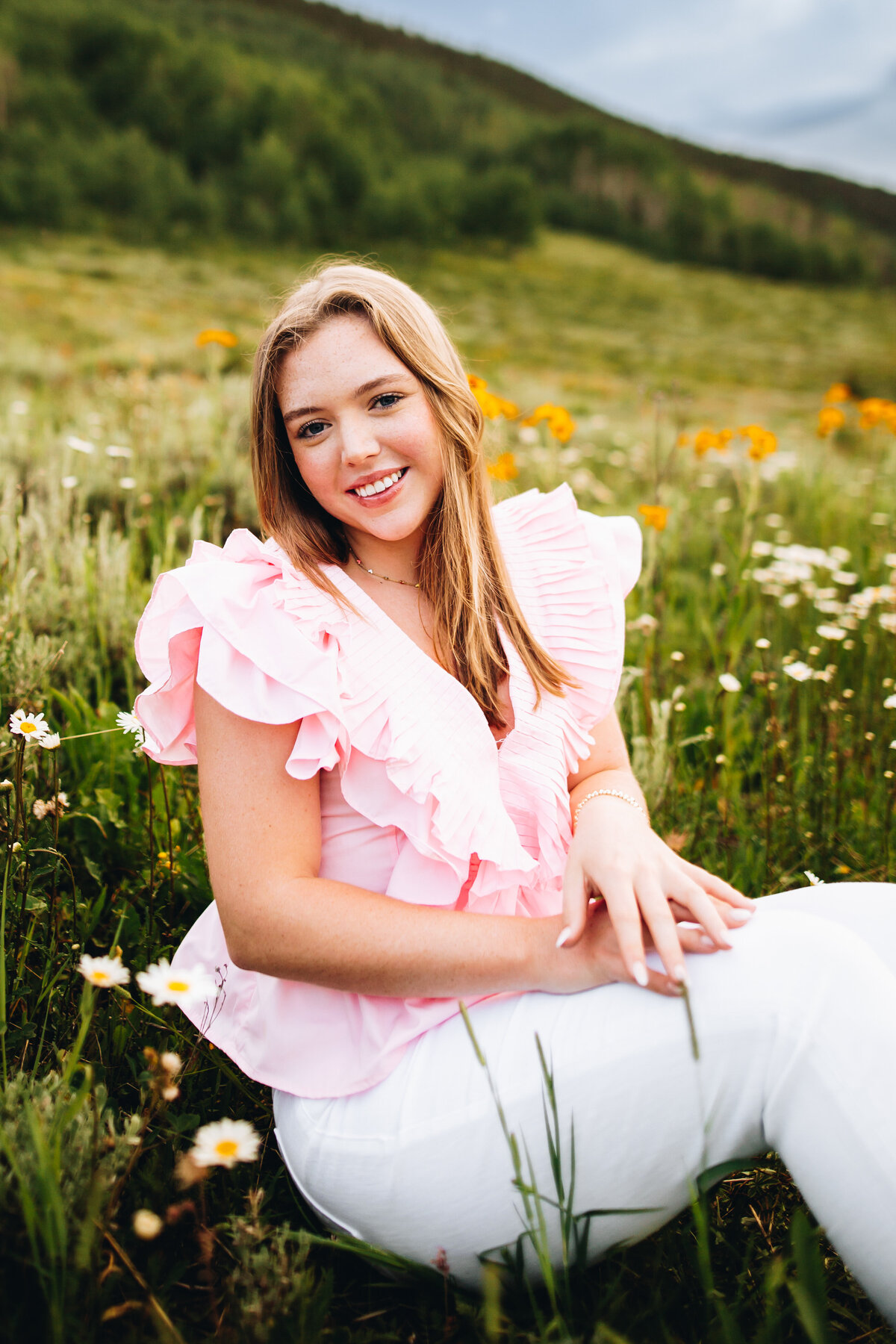 Kate poses in a field of wildflowers for her Crested Butte senior pictures.