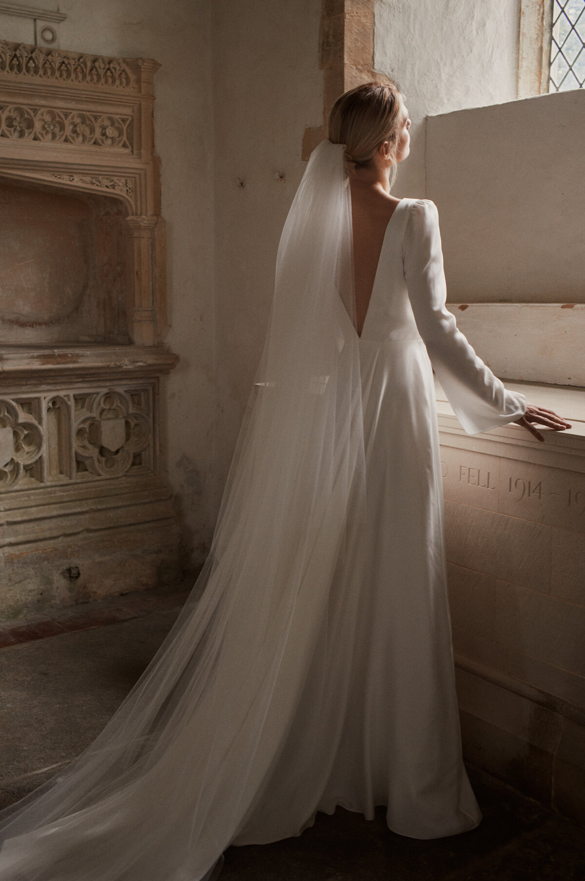 Deep v-neck long-sleeved wedding dress in silk on a bride
