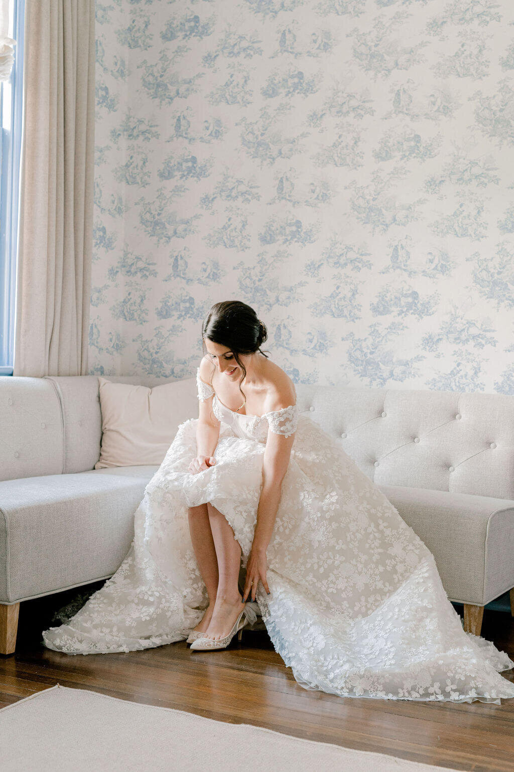 Bridal wedding photos of bride putting on shoes at Rust Manor House