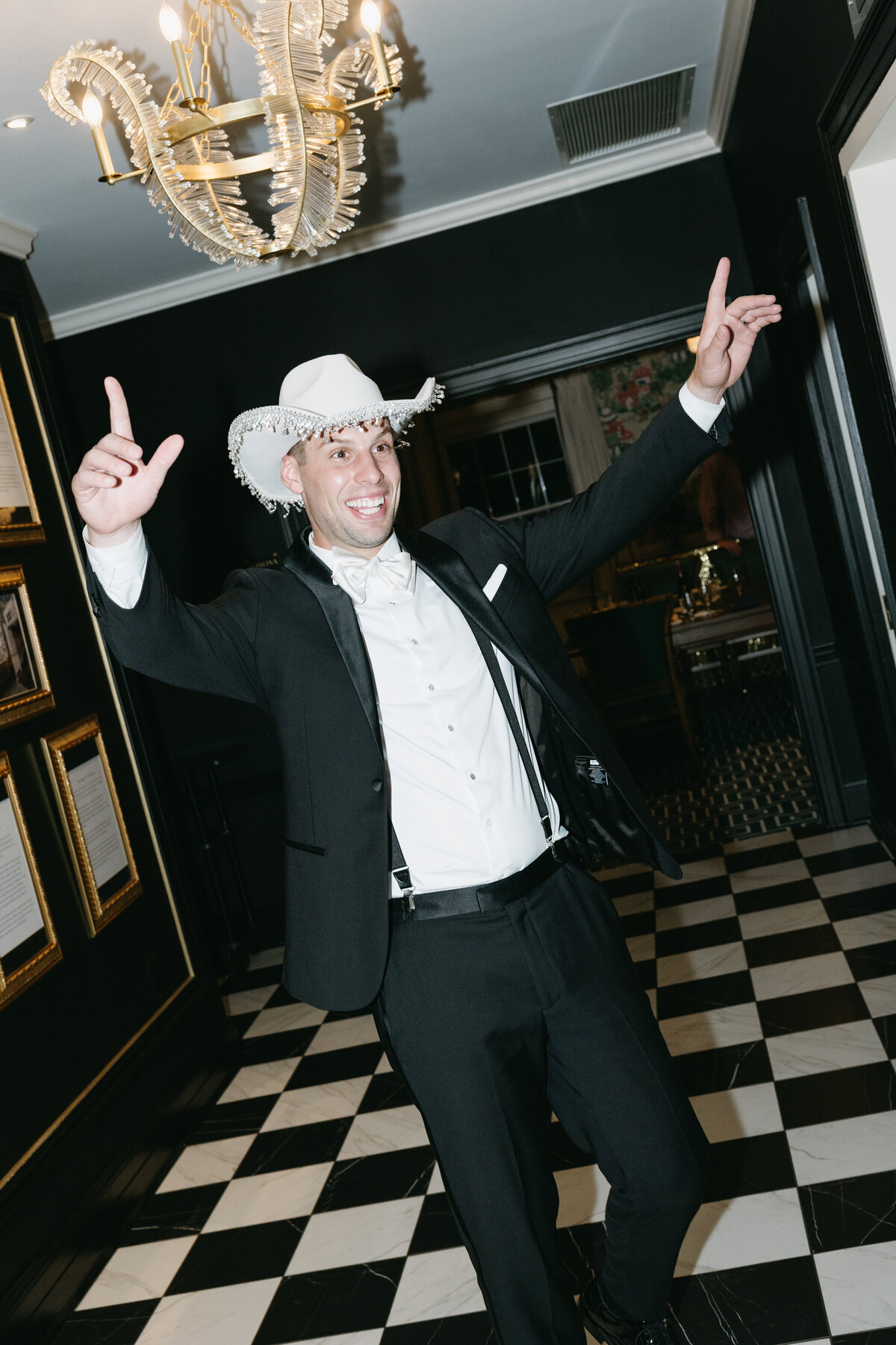 The groom, wearing a cowboy hat, radiates excitement as he prepares to celebrate his wedding reception at The Madison Club, capturing the fun and personal style of the day.