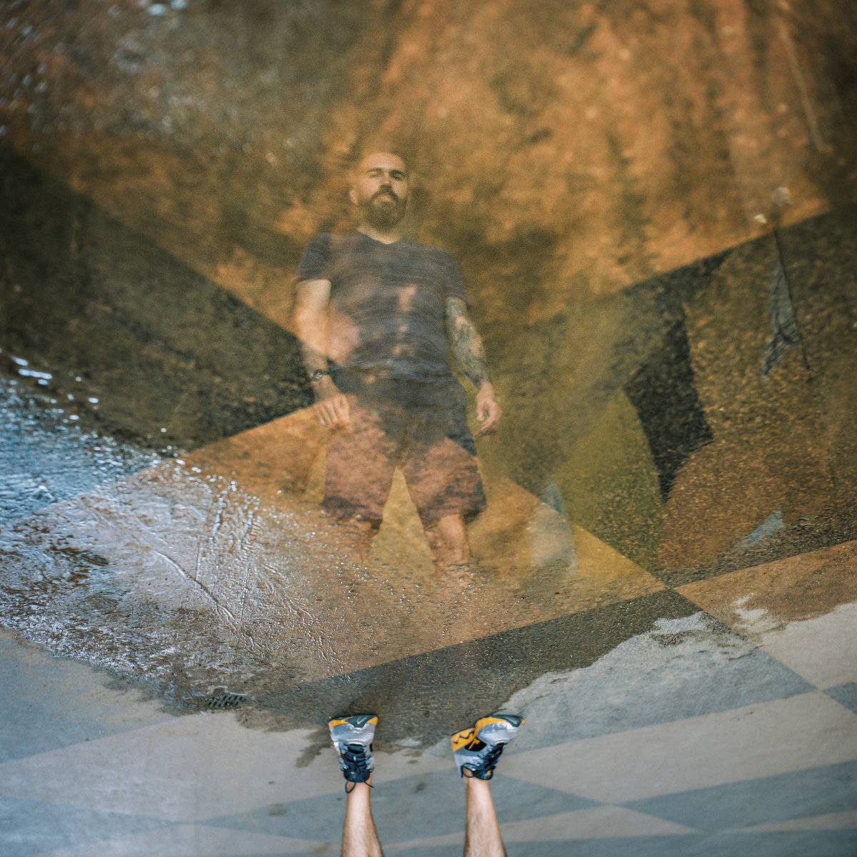 A reflection in standing water of a man upside down.