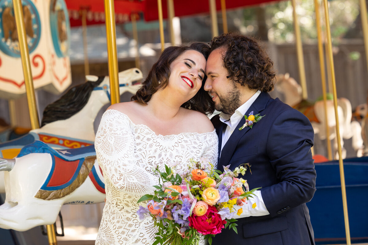 A bride resting her head on her grooms as they both smile