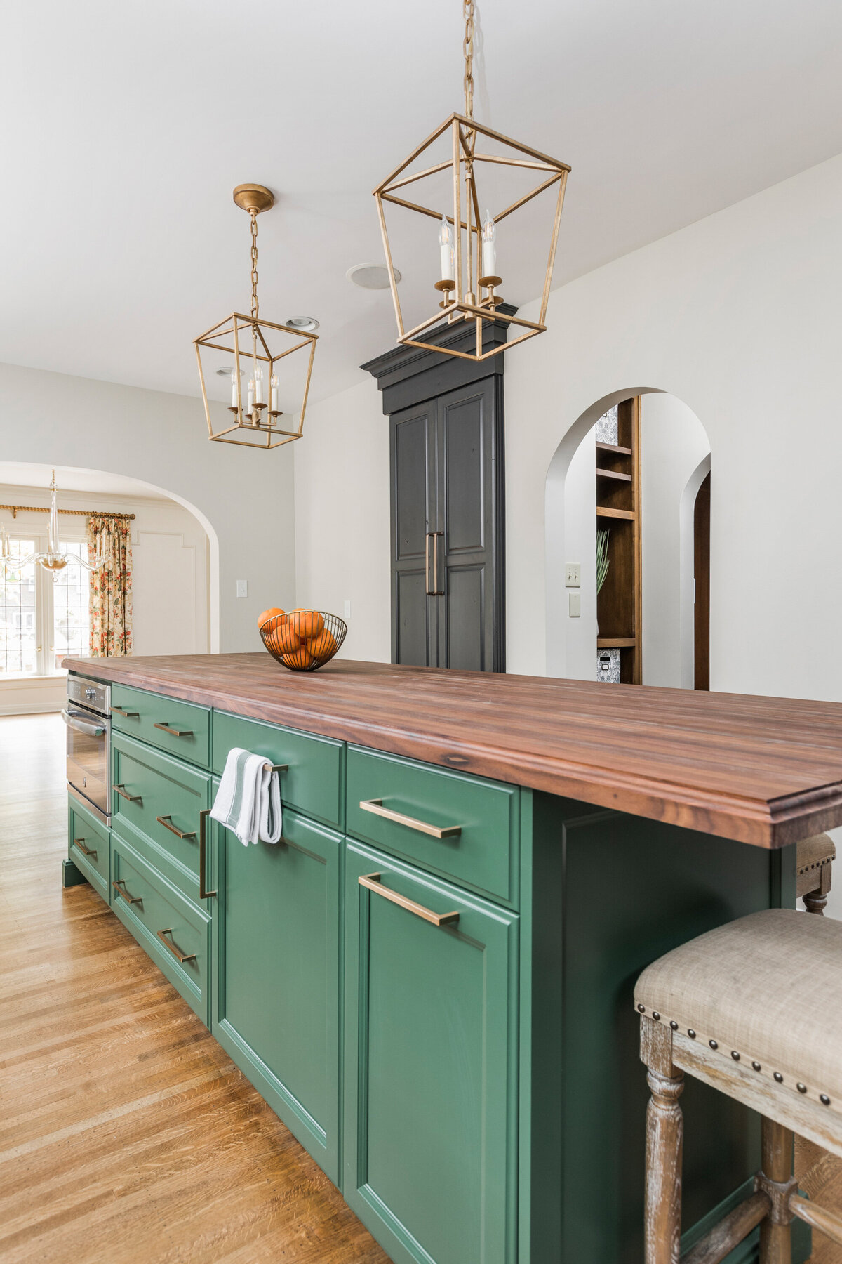 island with green cabinets and brown wood counter