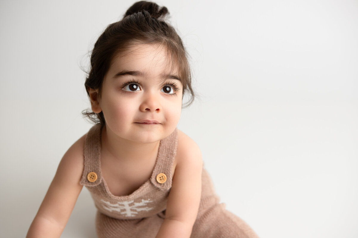 Picture of a toddler on a plain white backdrop studio photoshoot