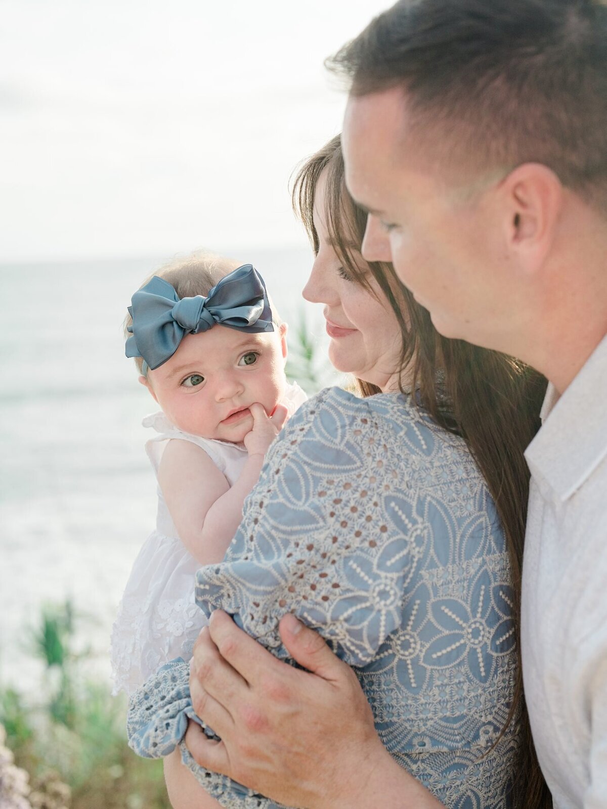 Family photoshoot of parents and baby girl at sea cliff coastal bluff trail in Del Mar