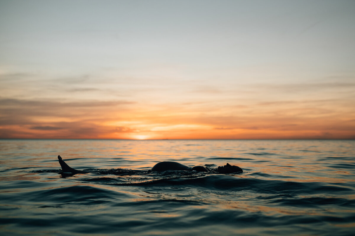 woman floating in ocean at sunset,  maternity photography Melbourne by And So I Don't Forget Photography