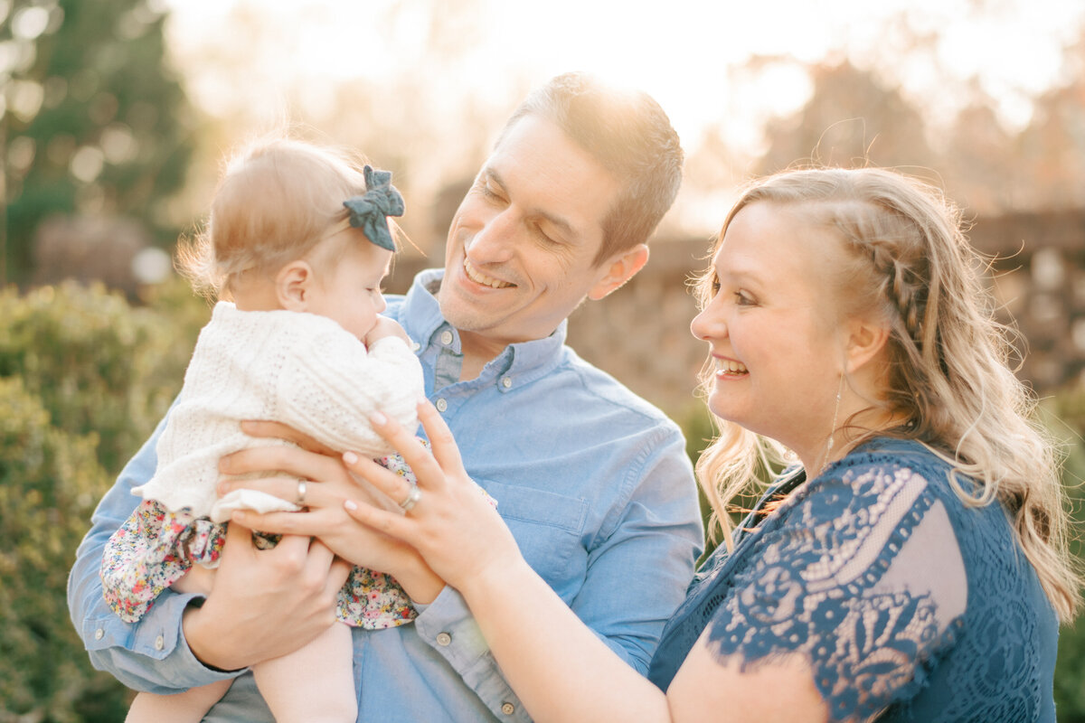 Family laughs and plays with their infant daughter. Image by Raleigh maternity photographer A.J. Dunlap Photography.