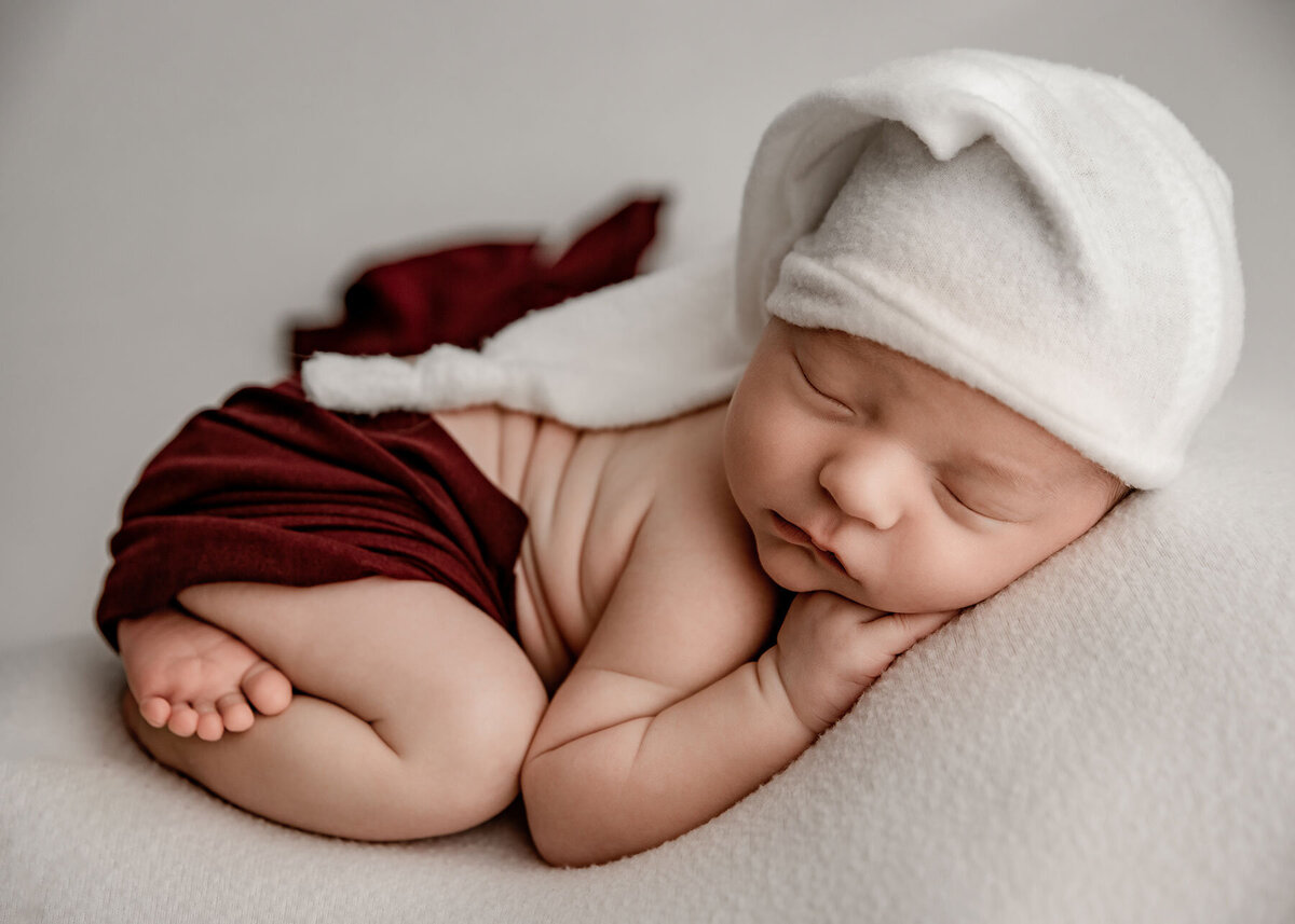 Pennsylvania-Newborn-Photography-baby-with-red-and-white-outfit-white-backdrop