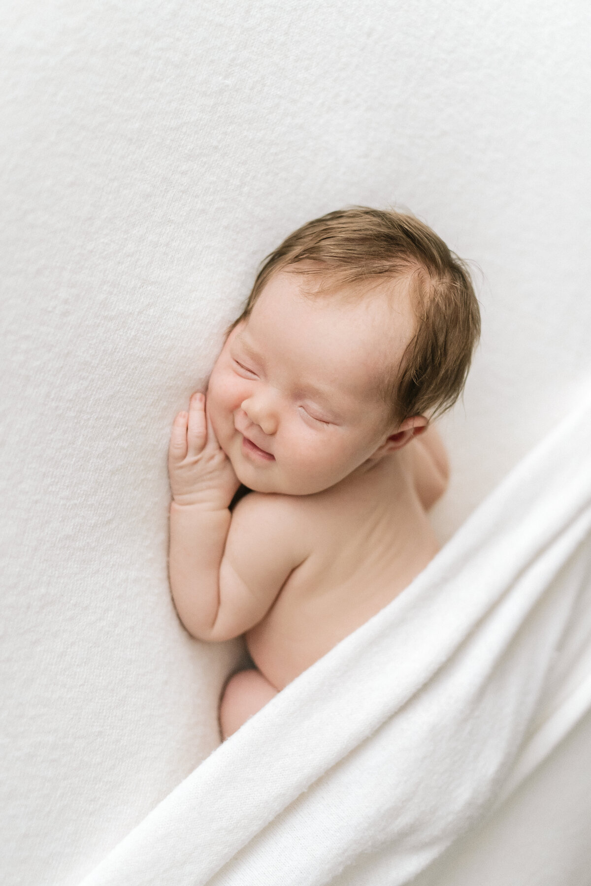 Cutest baby ever sleeping on a beanbag during an in-home newborn photoshoot