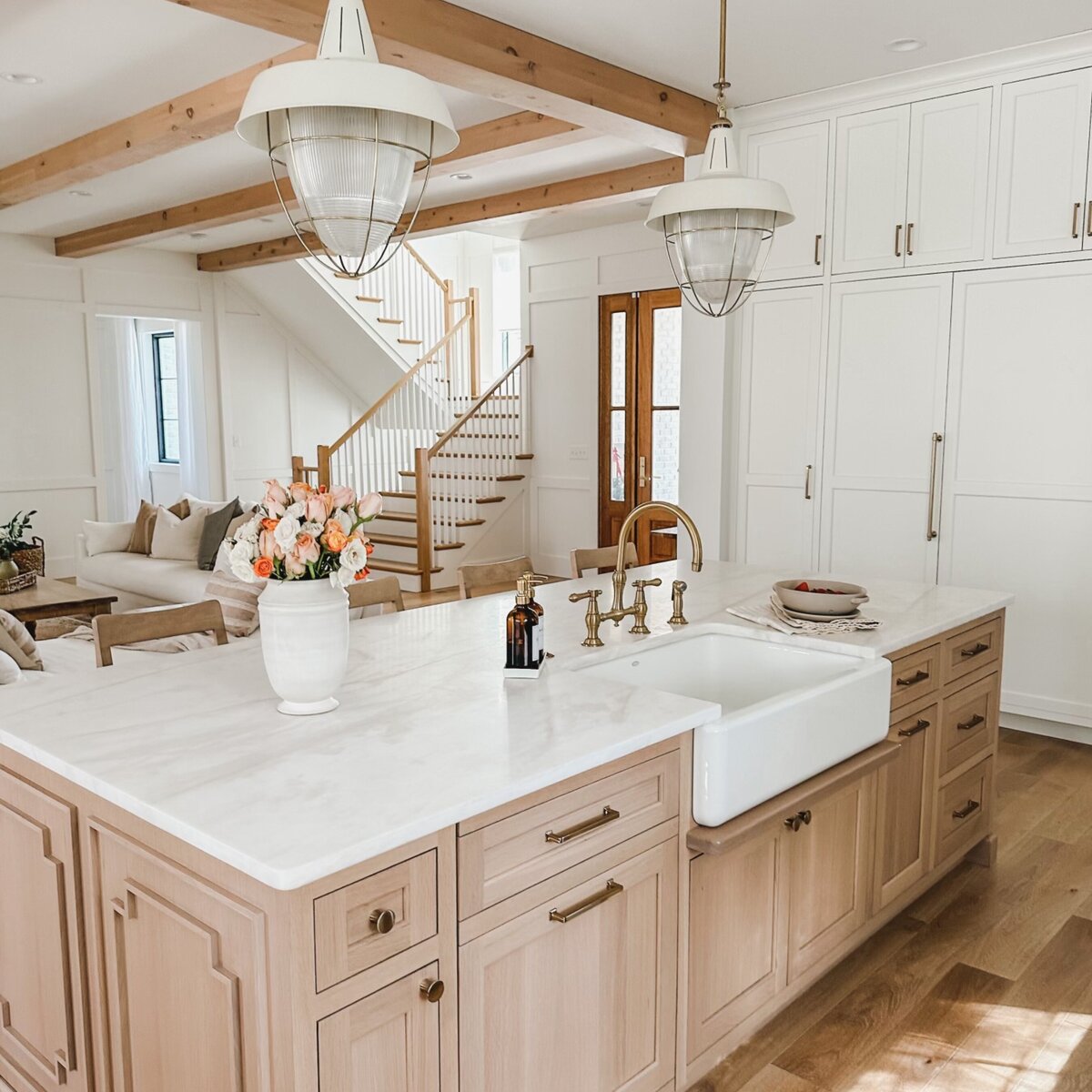 The kitchen features luxurious marble countertops and stunning brass hardware