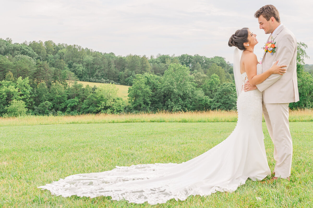 A loving couple in the Blue Ridge Mountains during their summer wedding by JoLynn Photography, a destination wedding photographer